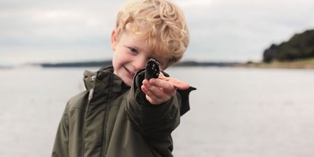 Dreng kigger på en musling. Foto: ROMU. Trine Sejthen.